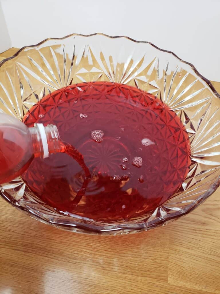 pouring red ICE drink into punch bowl