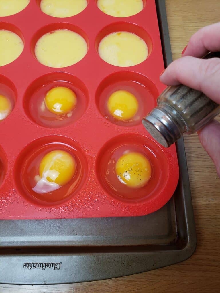 adding pepper to eggs in muffin pan