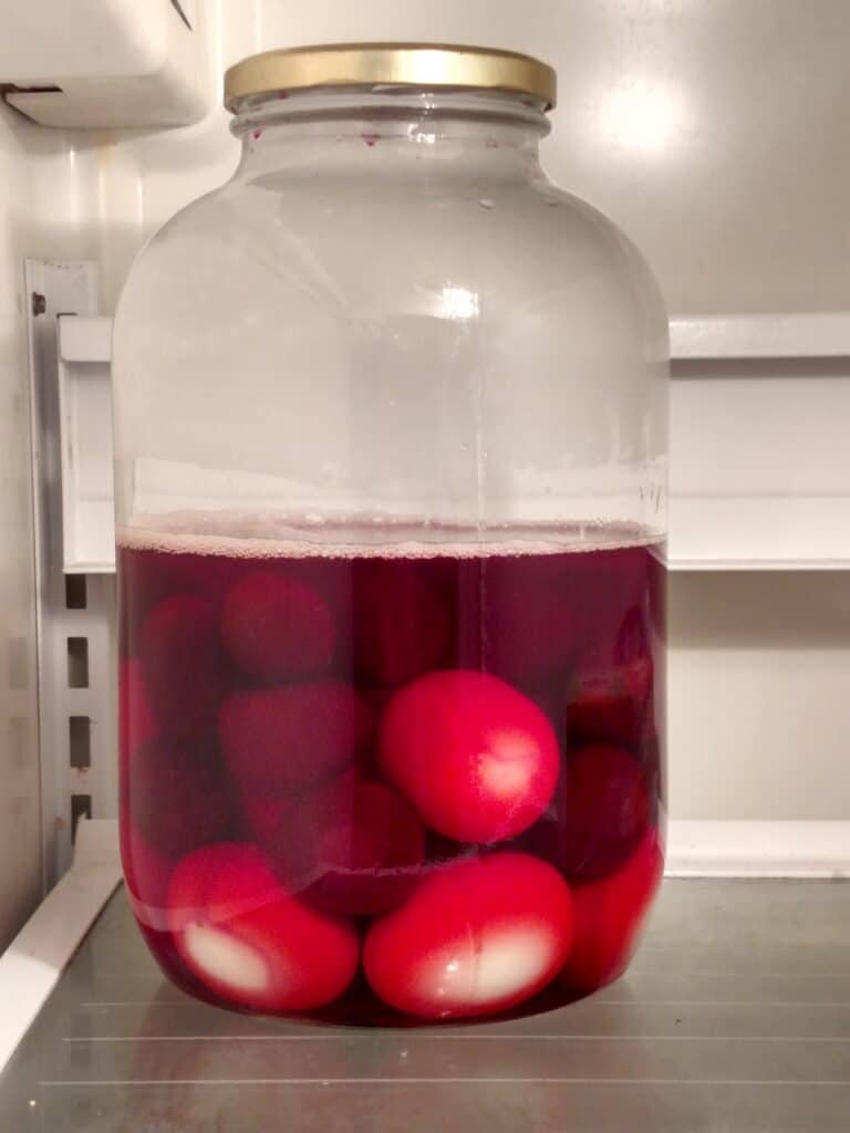 Red Beet Eggs in jar in refrigerator
