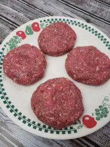 4 raw hamburgers on a plate