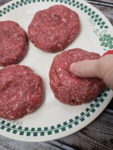 showing making a thumbprint in hamburger patty