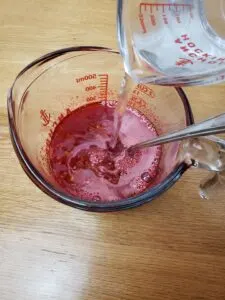 pouring water into red jello