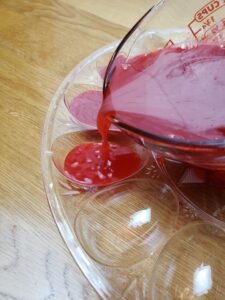 pouring red jello into deviled egg mold
