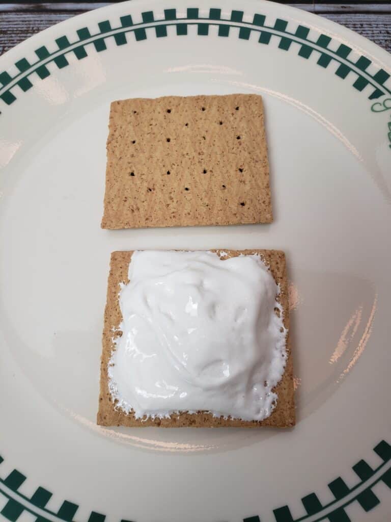 graham cracker and marshmallow cream sandwich open to show cream