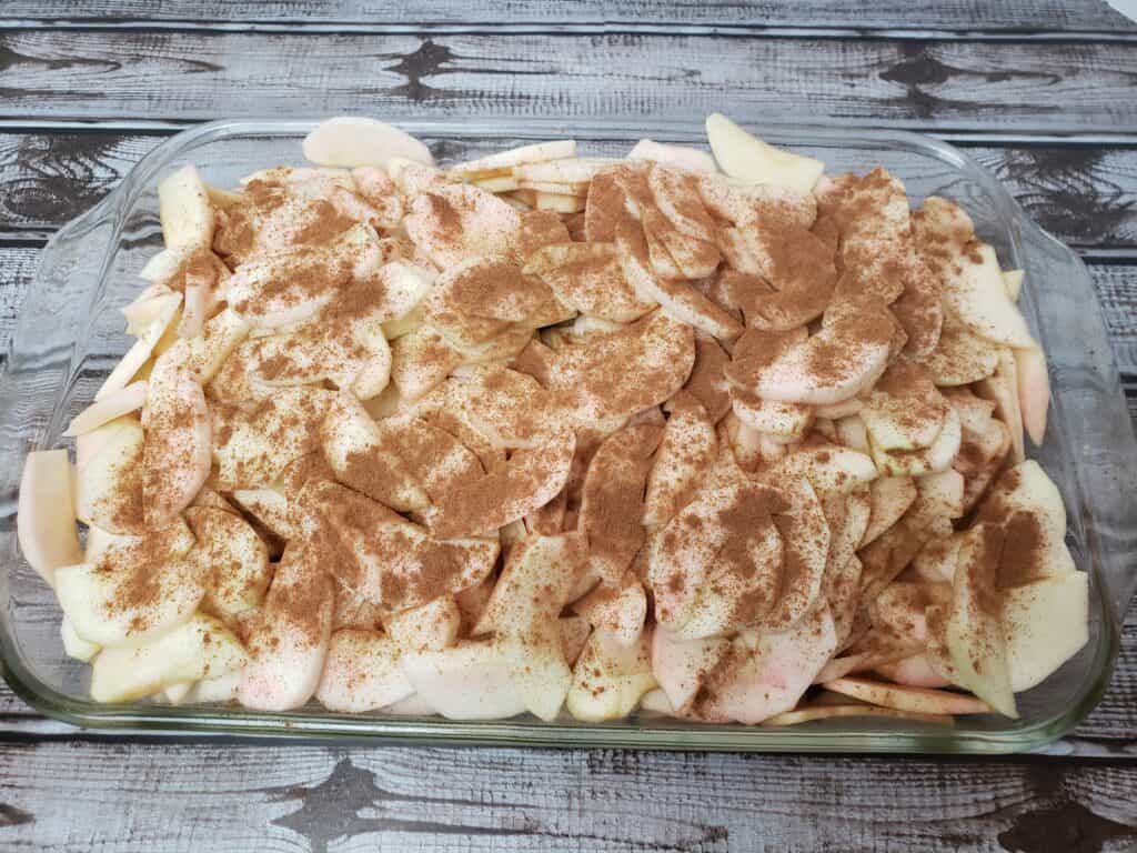 apples in baking dish with cinnamon on top