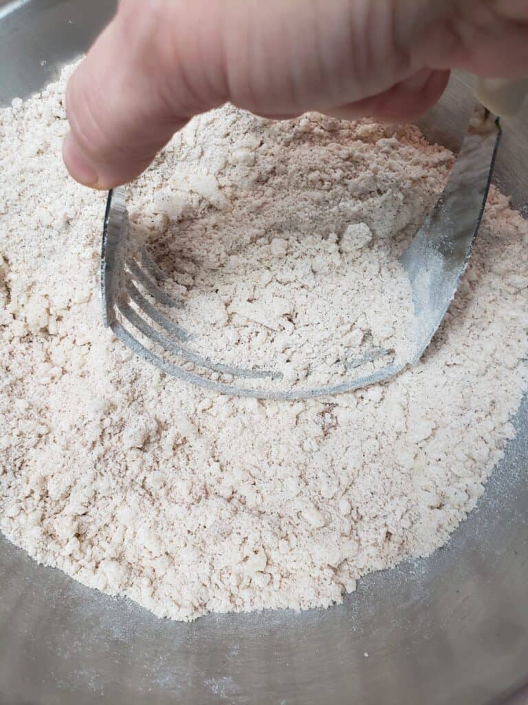 using pastry cutter to mix sugar, flour and butter