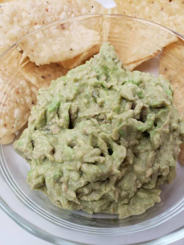 Simple creamy Guacamole and chips on white plate