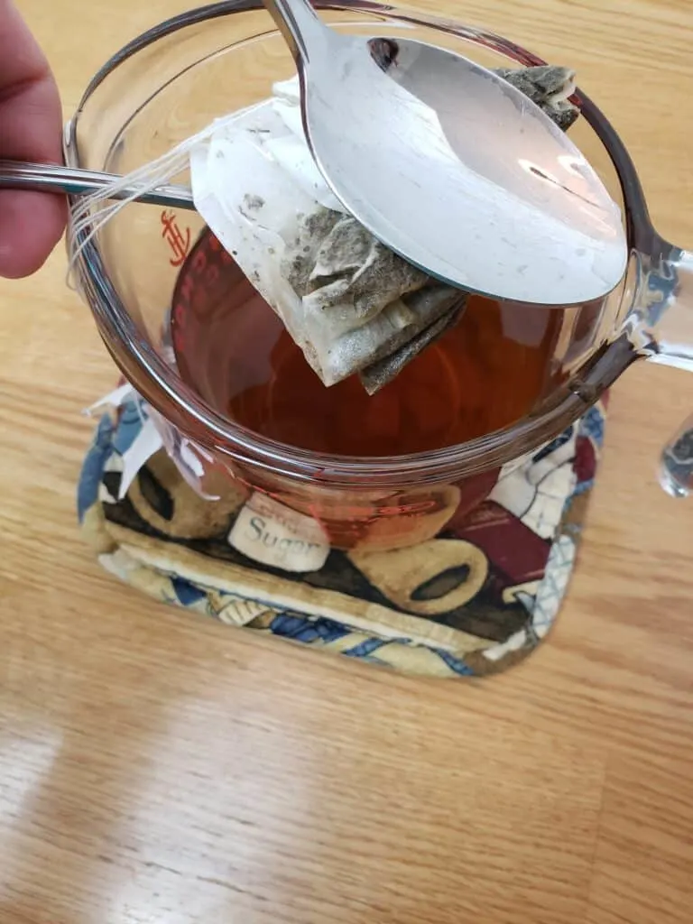 squeezing tea bags between 2 spoons