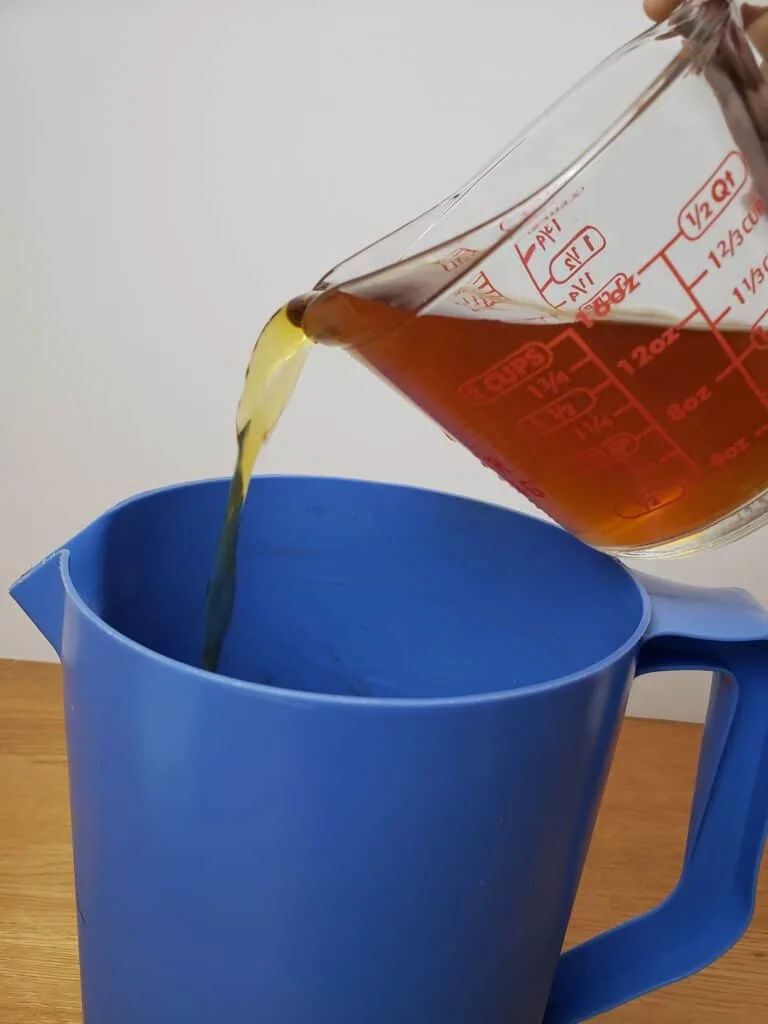 pouring concentrated tea into pitcher