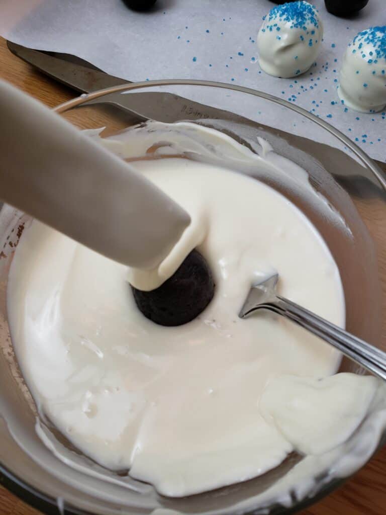 dipping truffle into white chocolate
