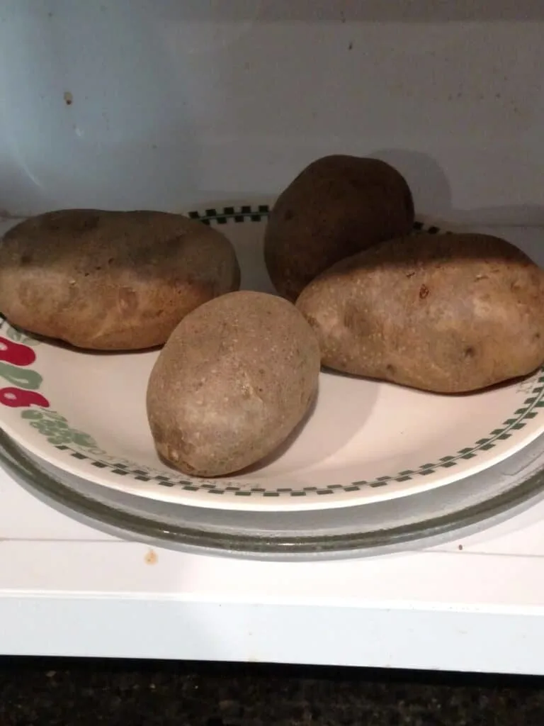 4 potatoes on plate in microwave
