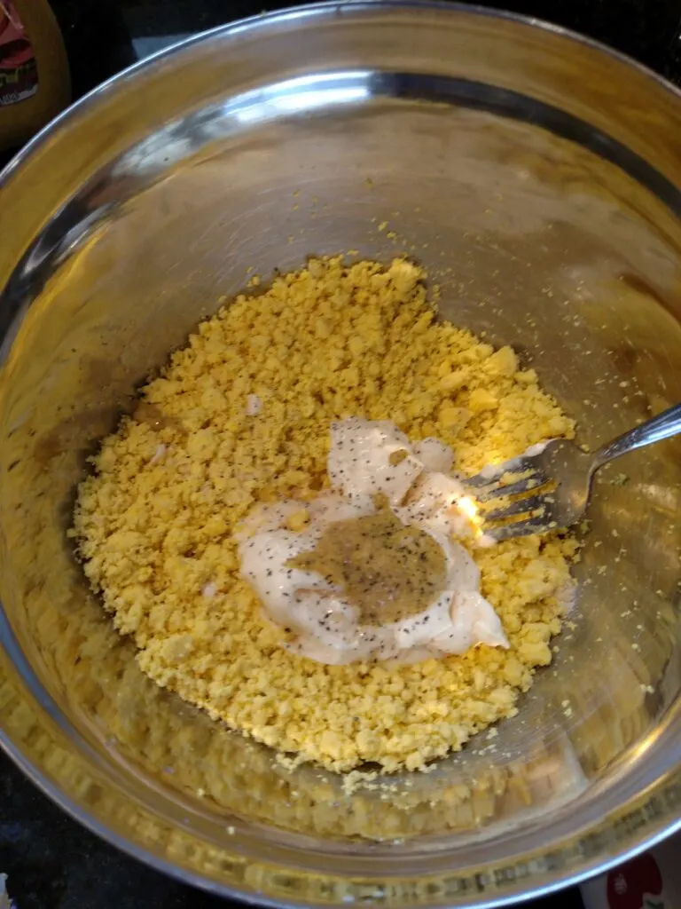 mayo, mustard, vinegar, salt and pepper added to mashed egg yolk.