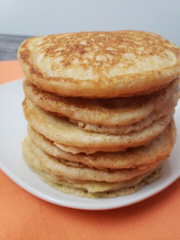 stack of 5 Multigrain Buttermilk Pancakes on a white plate.