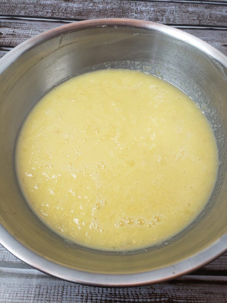 pineapple, eggs, sugar and flour mixed in bowl