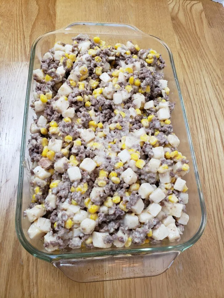 potato, corn, beef and soup mixture added to casserole dish