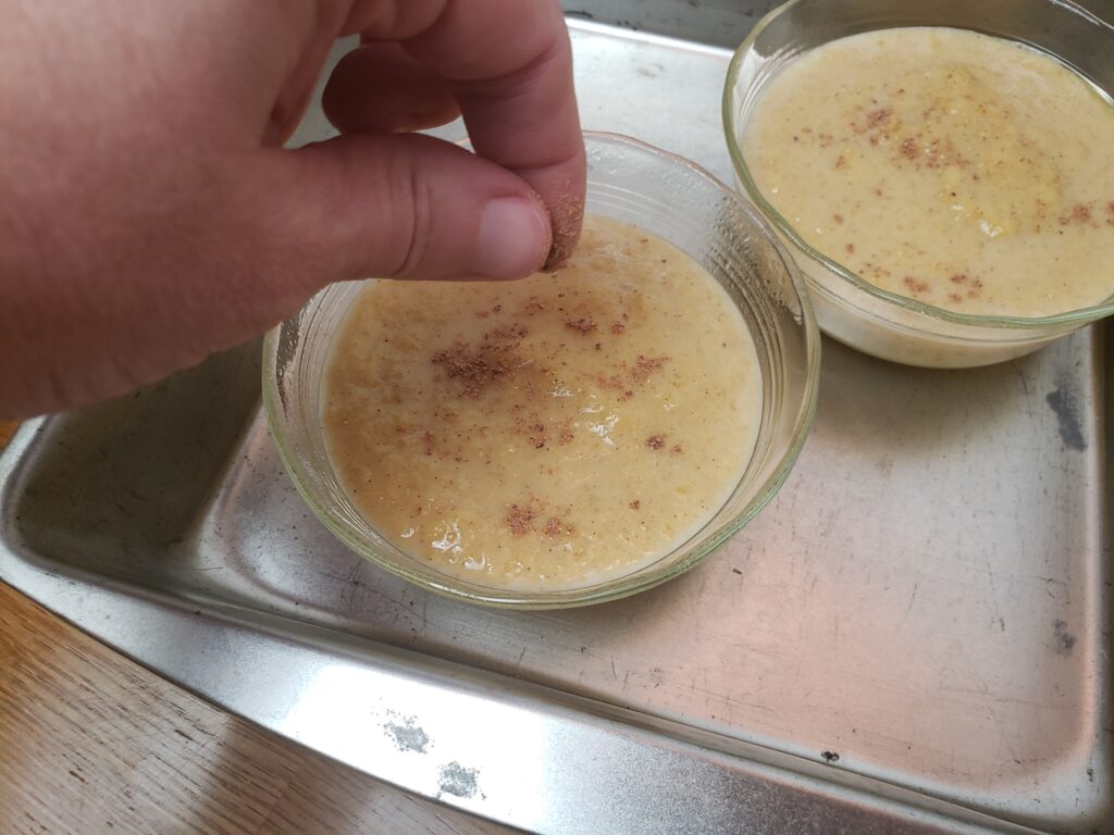 sprinkling nutmeg on top of custard