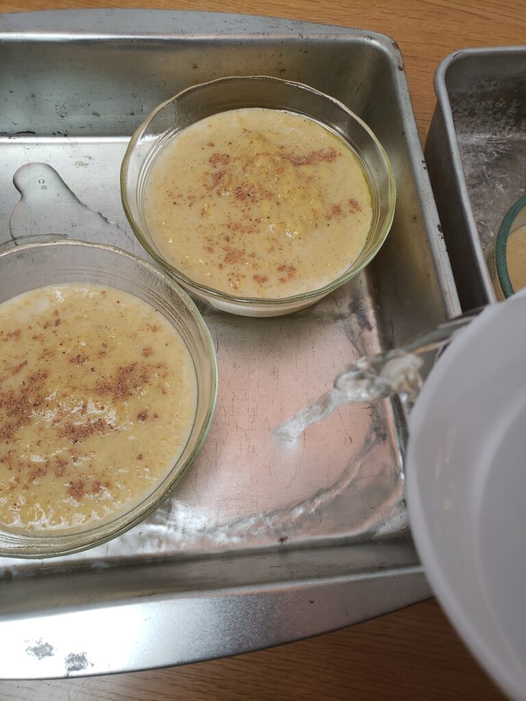 pouring water around custard cups in baking pans