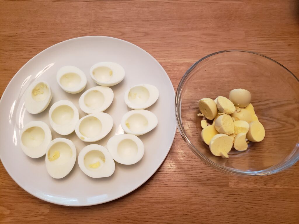 hard boiled eggs cut in half and yolks in bowl