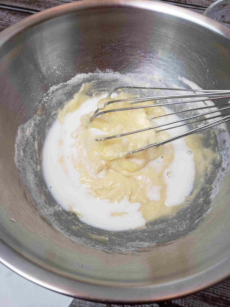 adding part of egg and sugar mixture