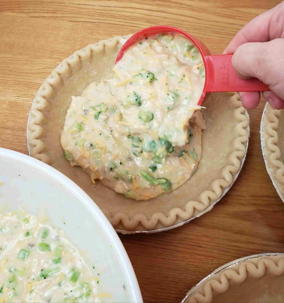 adding quiche filling to pie crust