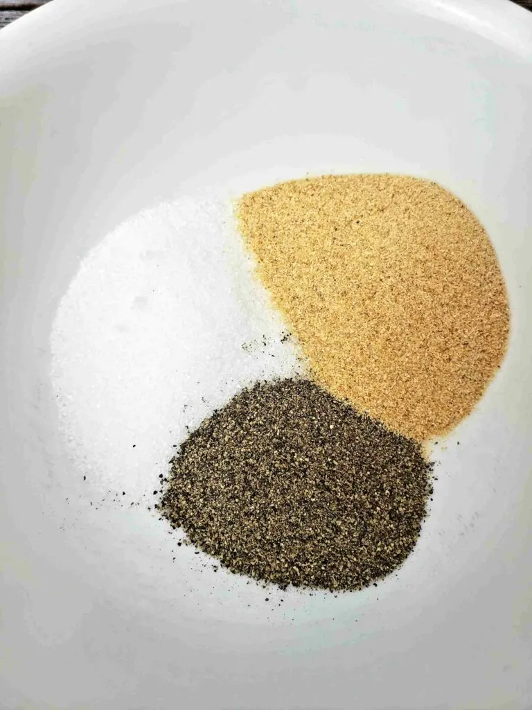 garlic, salt and pepper in a white bowl before mixing them together
