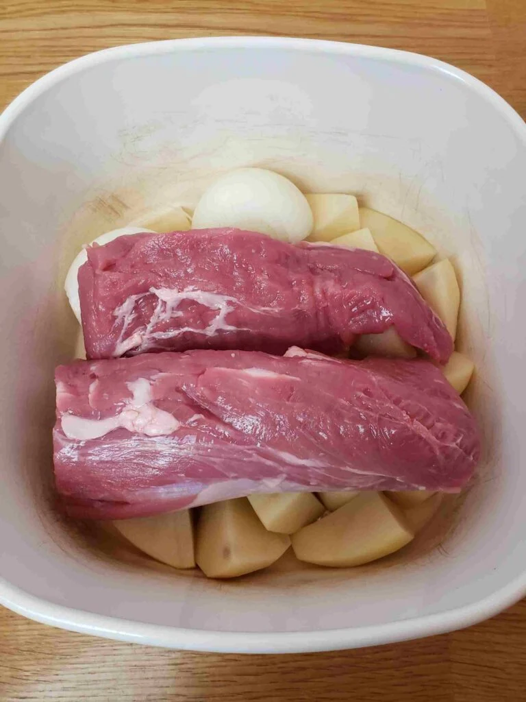 pork roast added over potatoes and onion