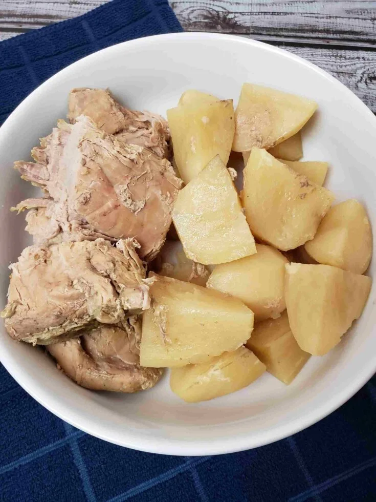 slow cooker pork and potatoes in white serving dish