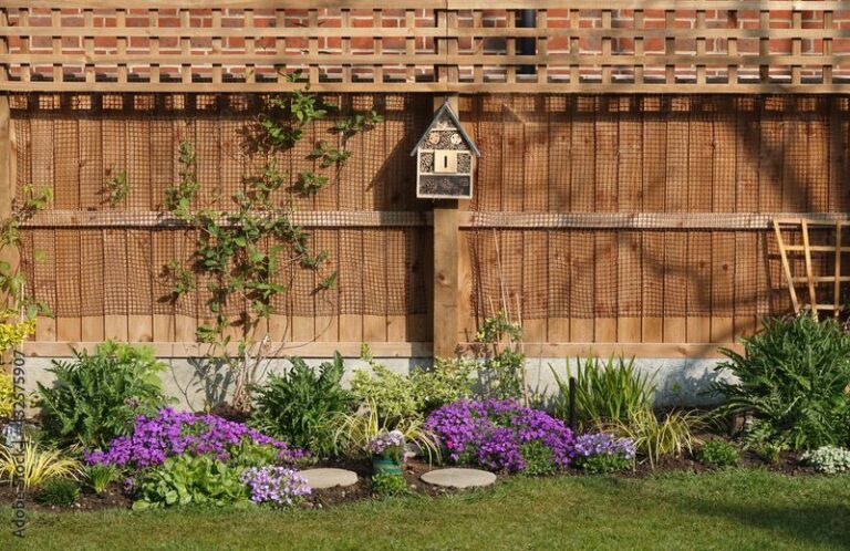 If Your Backyard Feels Flat And Bare, Here’s How A Plain Privacy Fence Turns Into A Birdhouse Garden